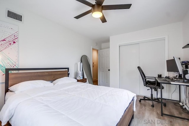 bedroom featuring ceiling fan, hardwood / wood-style flooring, and a closet