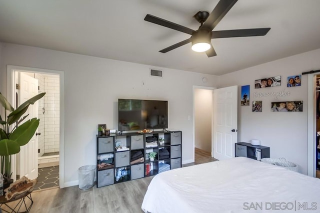 bedroom with hardwood / wood-style flooring, connected bathroom, and ceiling fan