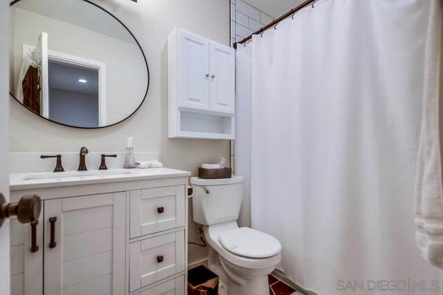 bathroom with toilet, vanity, and curtained shower