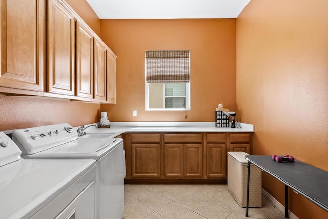 laundry room with cabinets, sink, light tile patterned flooring, and washing machine and clothes dryer