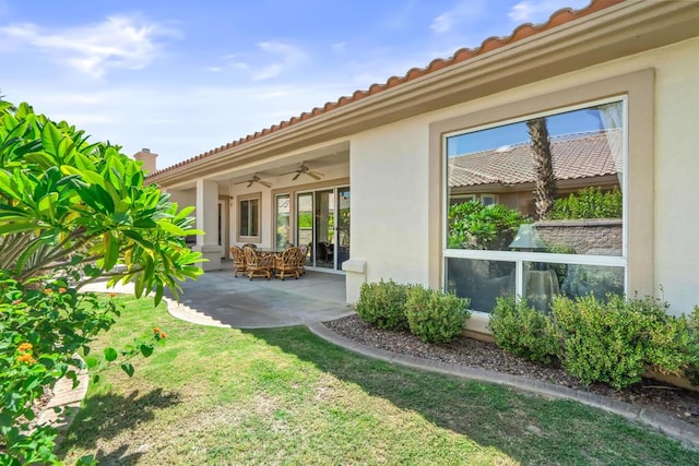 view of yard with ceiling fan and a patio