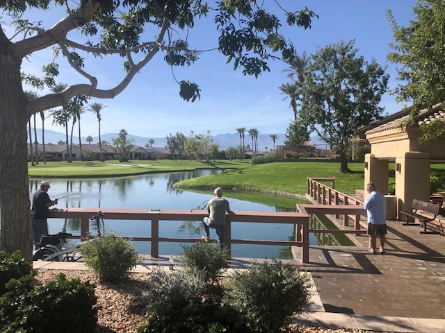 view of dock featuring a lawn and a water view