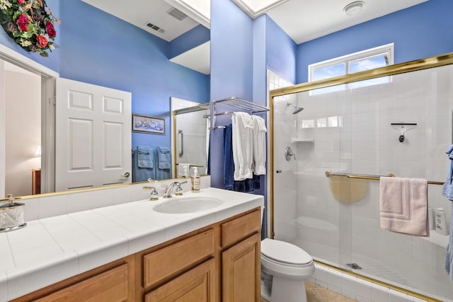 bathroom with vanity, toilet, tile patterned floors, and an enclosed shower