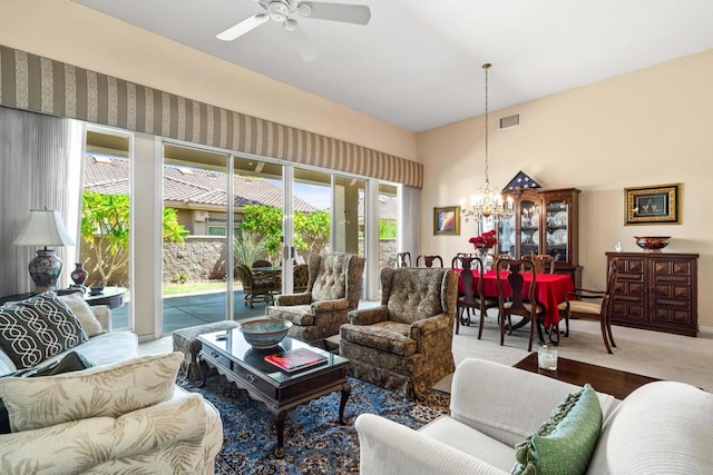 carpeted living room featuring ceiling fan with notable chandelier