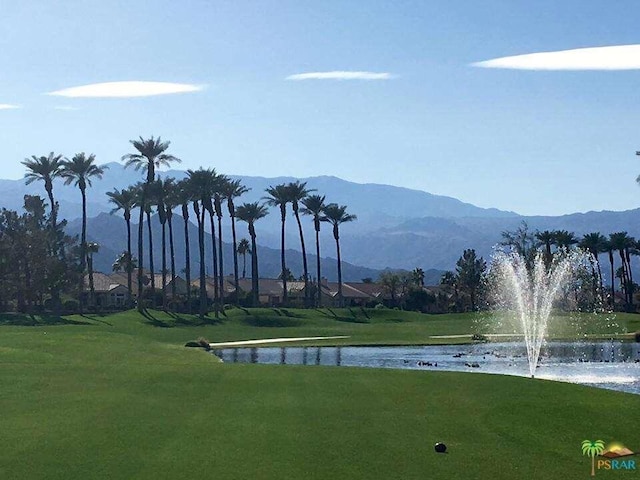 exterior space featuring a water and mountain view and a yard