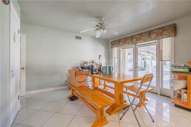 tiled dining room with ceiling fan and french doors