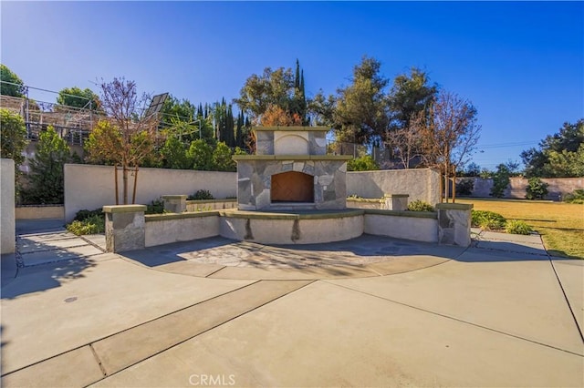 view of front of house featuring a patio area and an outdoor stone fireplace