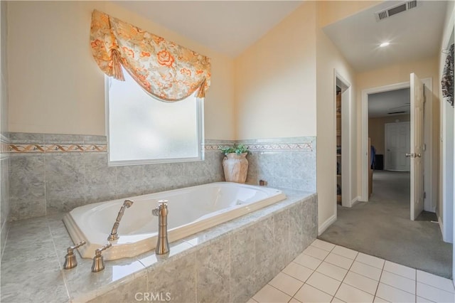 bathroom with tile patterned floors and tiled tub