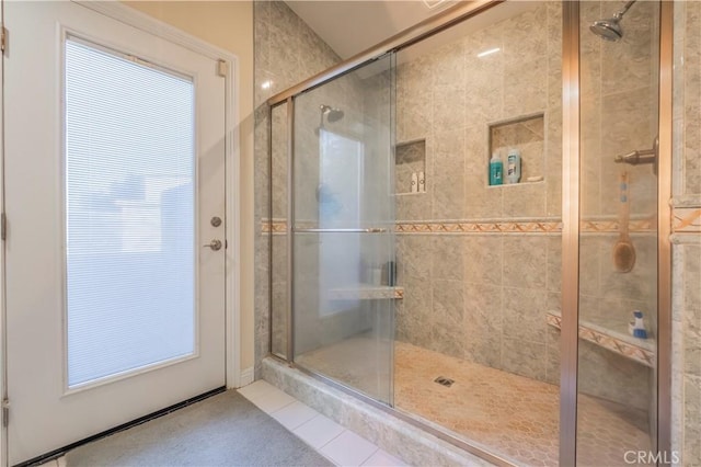 bathroom with a shower with shower door and tile patterned flooring