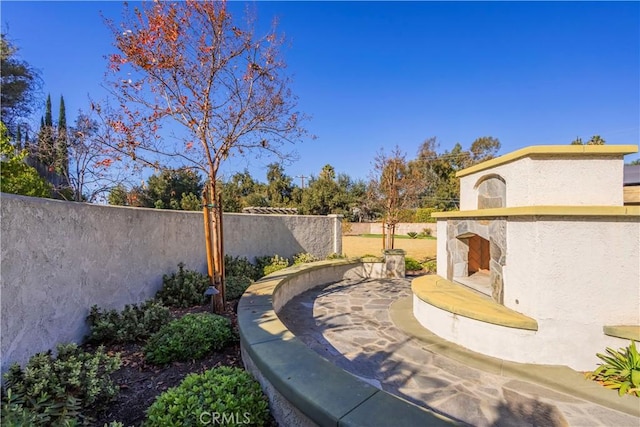 view of yard featuring an outdoor stone fireplace