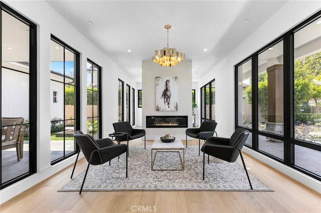 sitting room with light wood-type flooring and a notable chandelier