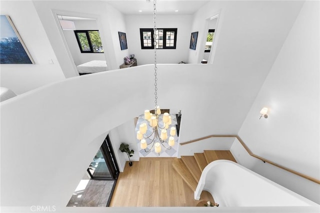 staircase featuring a chandelier and hardwood / wood-style flooring