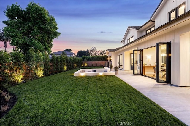 yard at dusk featuring a patio