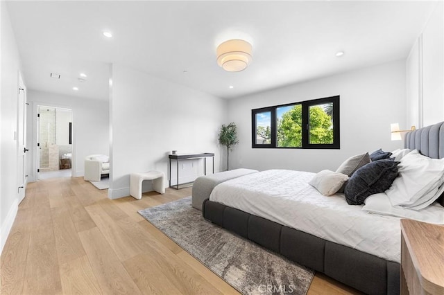 bedroom featuring ensuite bath and light hardwood / wood-style floors