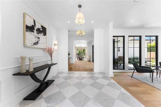 corridor featuring a chandelier and light hardwood / wood-style flooring