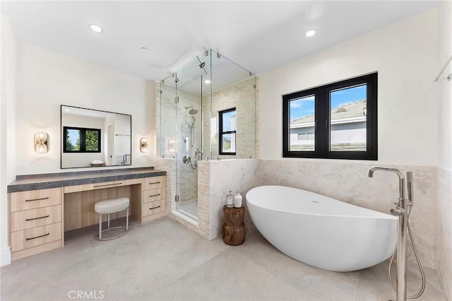 bathroom with vanity, tile walls, plenty of natural light, and shower with separate bathtub