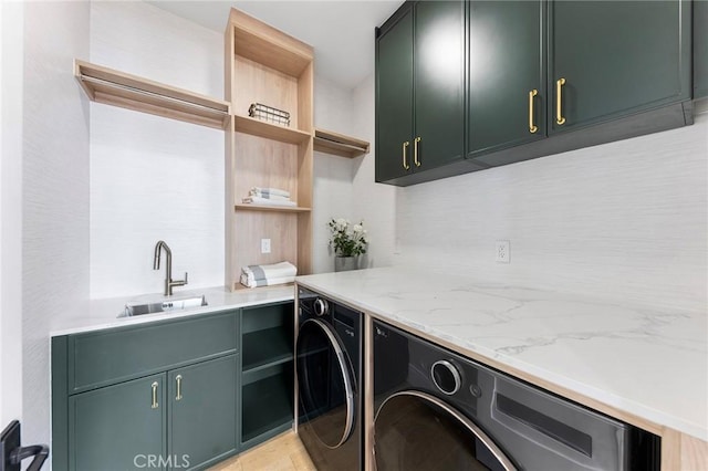 laundry room featuring cabinets, sink, and washing machine and clothes dryer