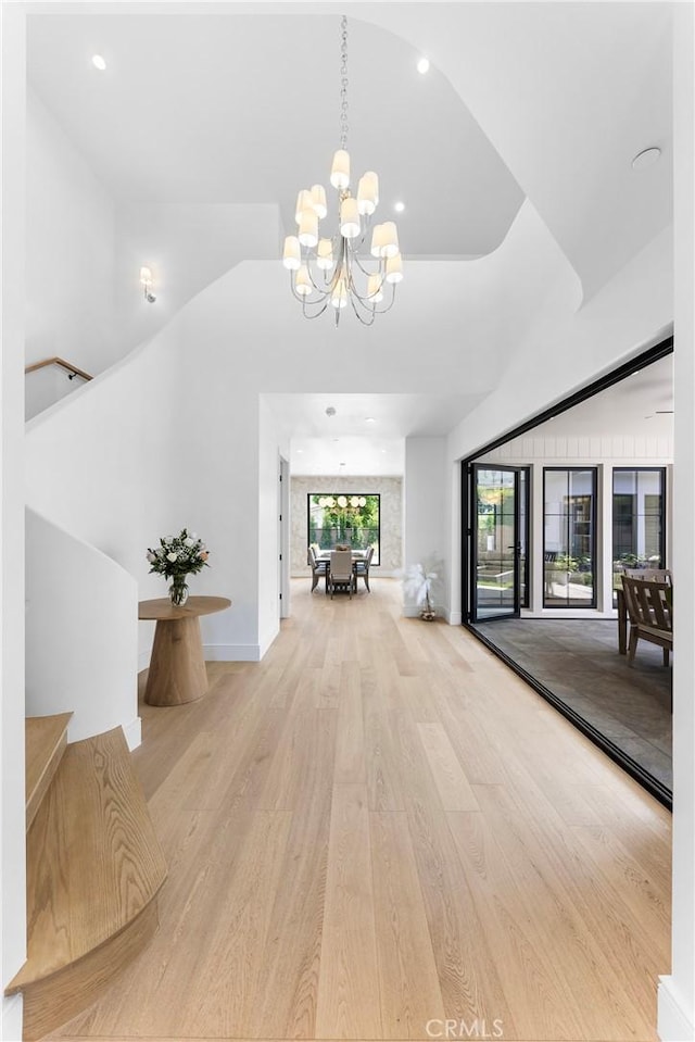 corridor featuring a chandelier and light hardwood / wood-style floors