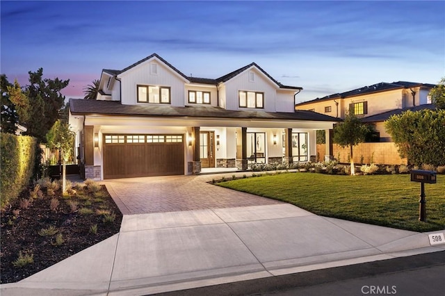 modern farmhouse style home featuring covered porch, a garage, and a yard