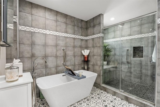 bathroom with separate shower and tub, tile walls, and tile patterned flooring