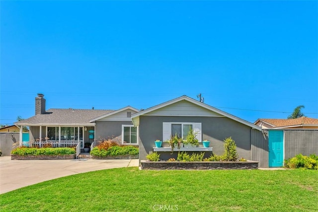 back of property featuring covered porch and a lawn