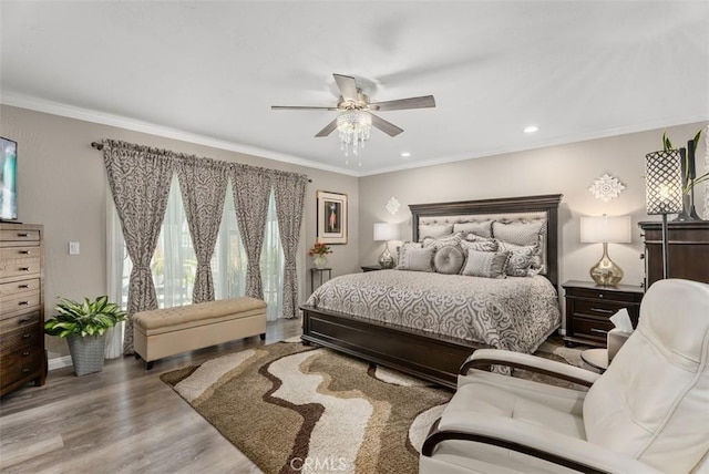 bedroom with ceiling fan, crown molding, and light hardwood / wood-style floors