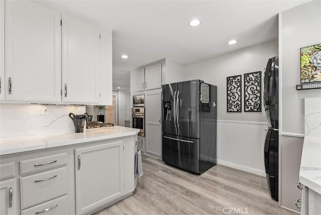 kitchen featuring light wood-type flooring, appliances with stainless steel finishes, and white cabinetry