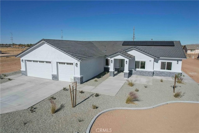 view of front of house featuring a garage and solar panels