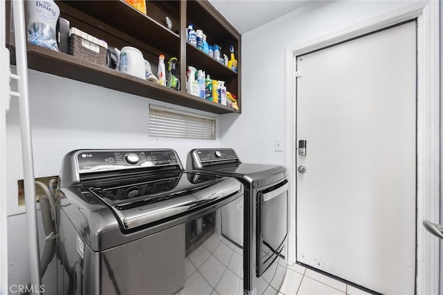 laundry area with separate washer and dryer and light tile patterned floors