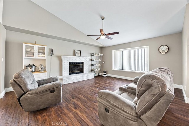 living room featuring ceiling fan, dark hardwood / wood-style flooring, lofted ceiling, and a fireplace