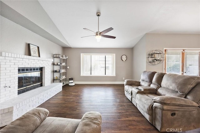 living room featuring a brick fireplace, dark hardwood / wood-style floors, lofted ceiling, and ceiling fan