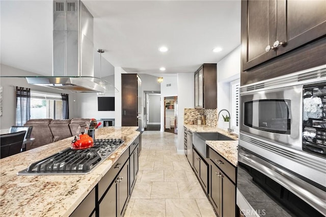 kitchen featuring light stone countertops, appliances with stainless steel finishes, tasteful backsplash, sink, and dark brown cabinets