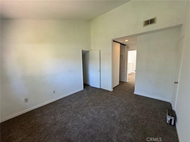 carpeted spare room featuring a high ceiling