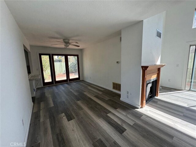 unfurnished living room featuring ceiling fan and dark hardwood / wood-style floors