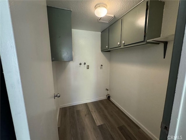 laundry room with cabinets, a textured ceiling, and dark hardwood / wood-style flooring