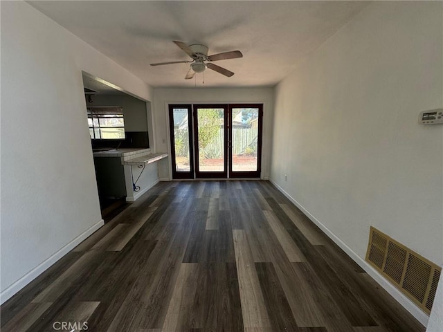 unfurnished living room featuring ceiling fan and dark hardwood / wood-style floors