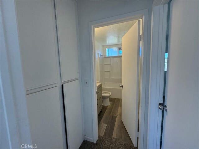 bathroom featuring toilet, a textured ceiling, wood-type flooring, and vanity