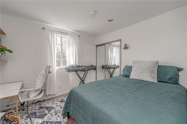 bedroom featuring baseboards, a closet, and wood finished floors