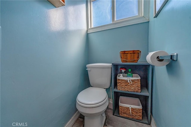 bathroom featuring baseboards and toilet