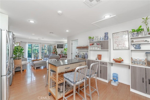 dining space featuring light wood-type flooring, attic access, visible vents, and recessed lighting