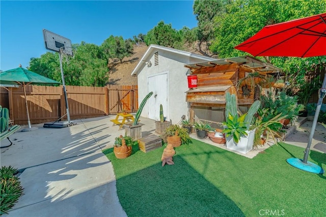 view of yard with a storage shed, a patio, an outdoor structure, and fence