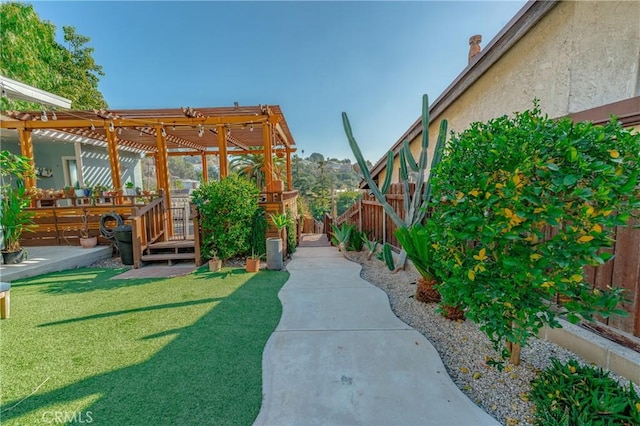 view of yard featuring a fenced backyard, a deck, and a pergola