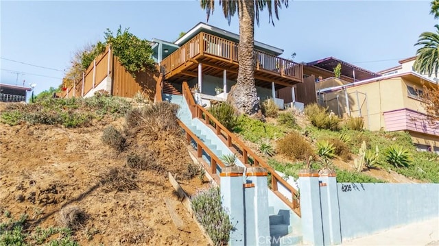 view of front of house featuring stairway and fence