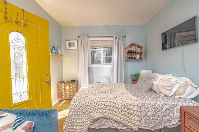 bedroom with lofted ceiling, baseboards, and wood finished floors