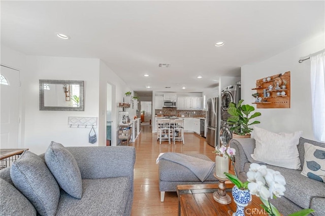 living room with light wood-style floors, visible vents, and recessed lighting