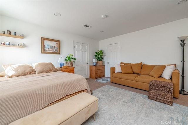 carpeted bedroom featuring visible vents