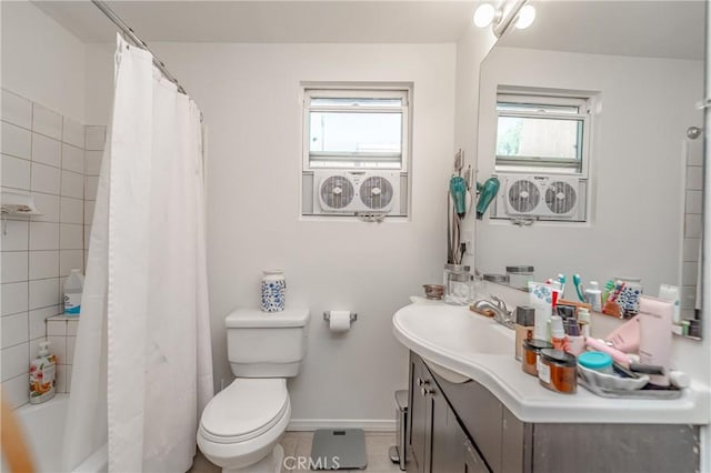 bathroom featuring toilet, vanity, a wealth of natural light, and baseboards