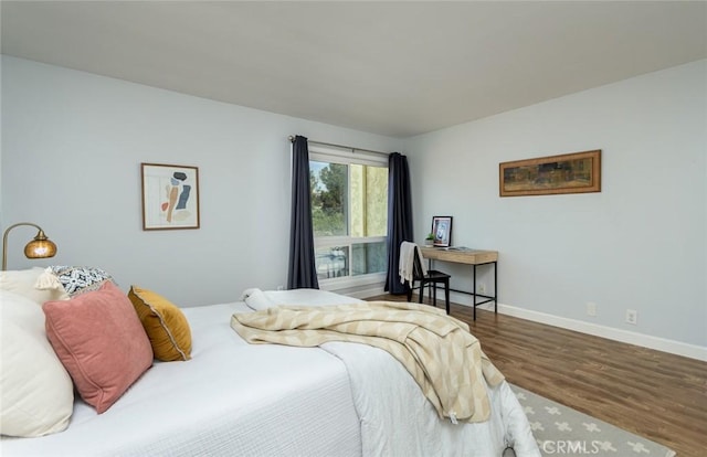 bedroom with dark hardwood / wood-style flooring