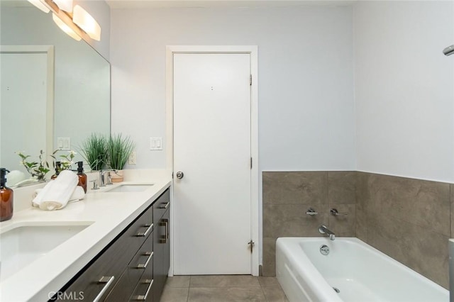 bathroom with a tub, tile patterned floors, and vanity