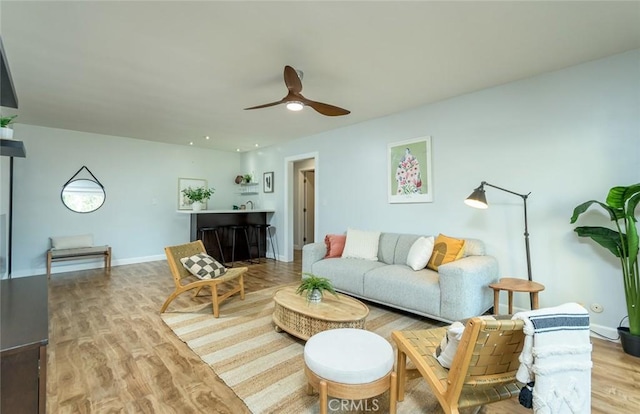 living room with ceiling fan and light wood-type flooring